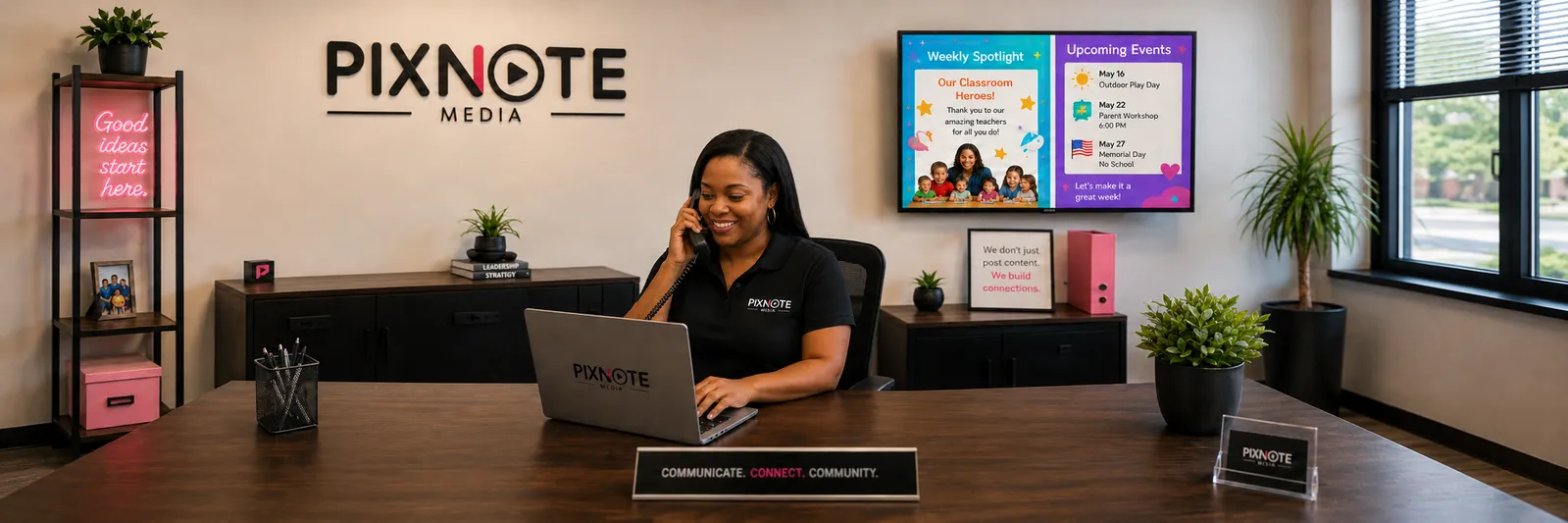 A PixNote team member on the phone at her office desk, with the PixNote Media logo and a sample parent board on the wall.
